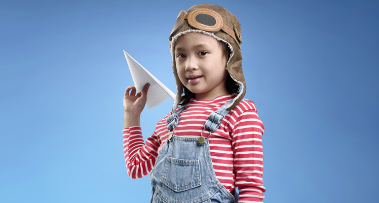 Child holding paper airplane