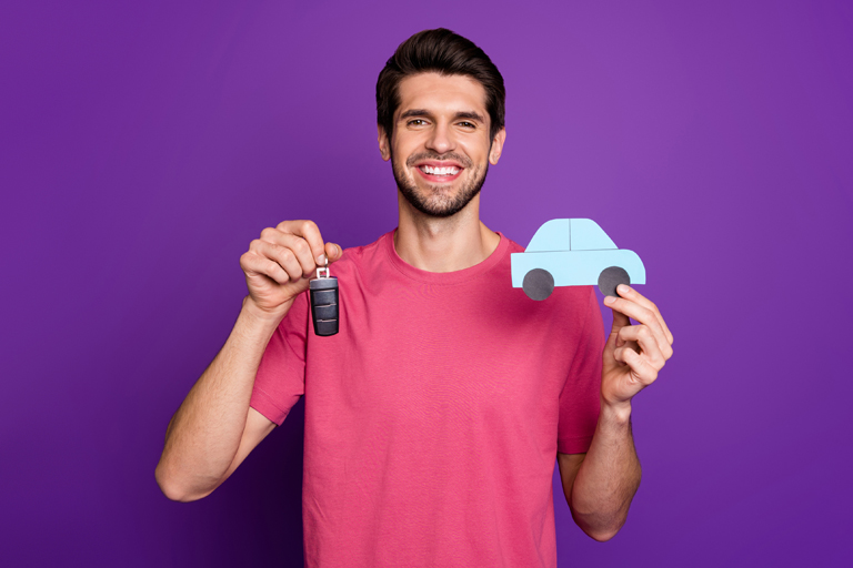 Man holding keys and cutout car